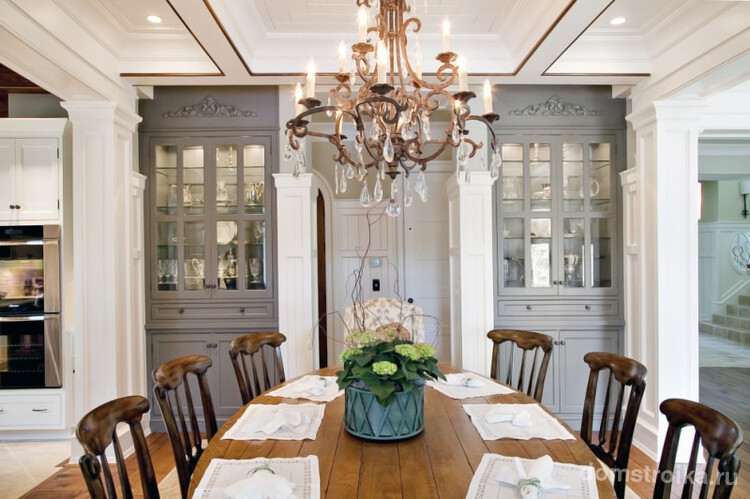 Столовая в классическом стиле отделена от кухни красивыми колоннами по бокам