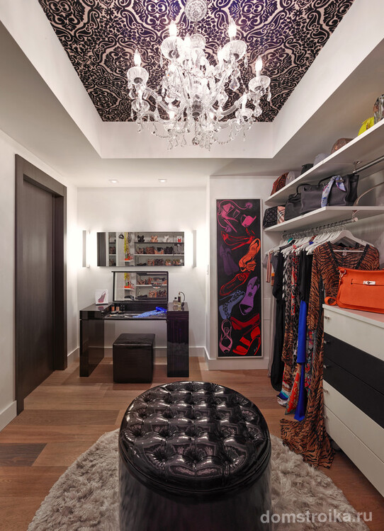 Уютная современная гардеробная комната с большим кожаным пуфом в центре комнаты