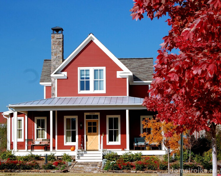 Гармоничное сочетание фасада частного дома и декоративного клена с красной листвой