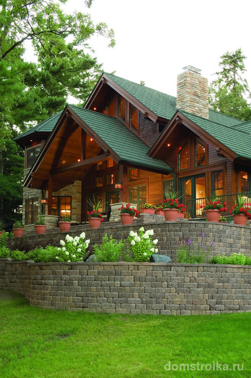 Красивый деревянный дом с крышей, окрашенной резиновой краской зеленого цвета