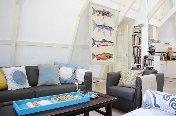 Декоративное полотно с рыбами дополняет интерьер современной гостиной