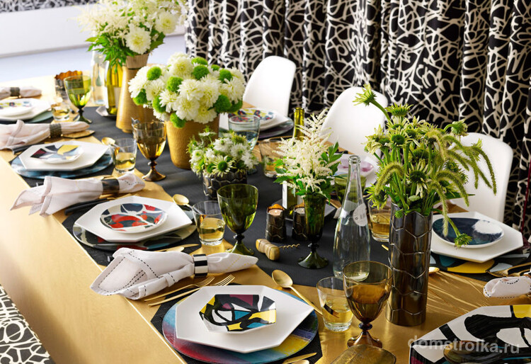 Геометричная форма ярко раскрашенной посуды и букеты полевых цветов в центре стола