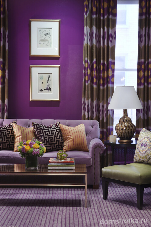 Насыщенные сиреневые обои в гостиной можно поддержать ковролином и, к примеру, большим диваном более светлых оттенков