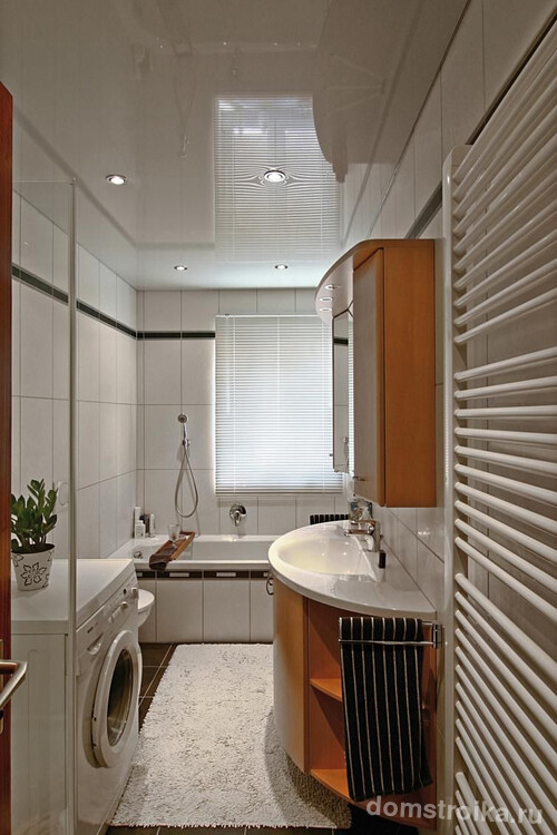 Светлый цвет глянцевого потолка расширяет пространство в небольшой ванной комнате