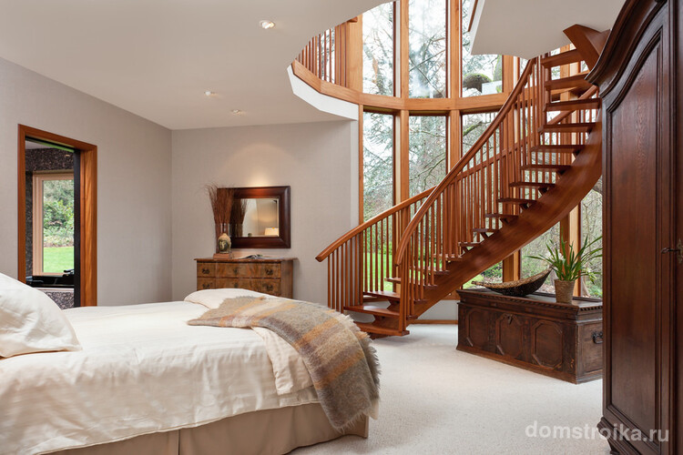 Деревянная лестница в тандеме с панорамным остеклением визуально расширяют границы этой спальни, превращая ее в максимально светлое и воздушное пространство