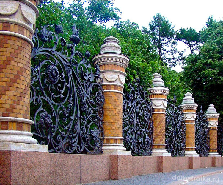 Роскошный, величественный кованый забор с монументальными опорами из кирпича