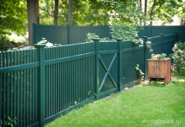 Низкая ограда из штакет, окрашенная в зеленый цвет