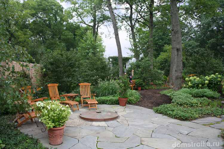 Просторный сад с оригинальной плиткой и уютной зоной отдыха