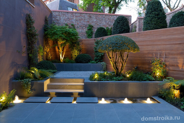 Интересная многоярусная конструкция в саду, оснащенная точечным освещением и подсветкой ступенек