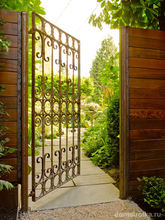 Легкие и очень воздушные кованые ворота у входа в сад создают приветливое настроение для гостей