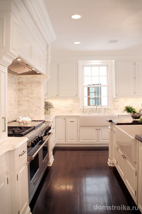 Отделка поверхностей классической белой кухни: каменная плитка для стен, натуральное дерево для пола и подвесной потолок
