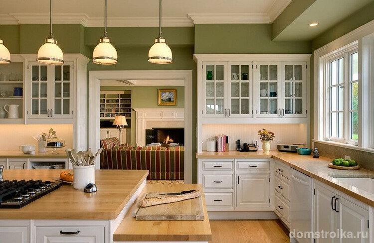 Приглушенный зеленый цвет обоев, белый кухонный гарнитур, деревянный пол и столешницы – дизайн интерьера классической кухни. Использование строгих форм и сочетаний – правило стиля