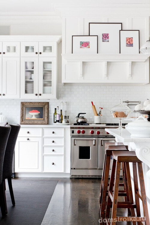 Классическая белая кухня с фарфоровой посудой, спрятанной за кухонными фасадами, обеденным столом с гипсовой лепниной, авторской живописью и другими интерьерными элементами