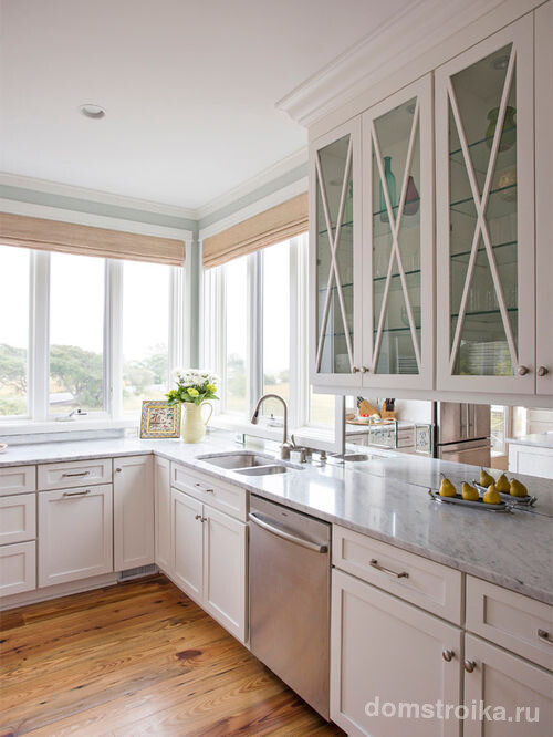 Зеркальный фартук и дневной свет создают впечатление отсутствия границ в кухонном пространстве