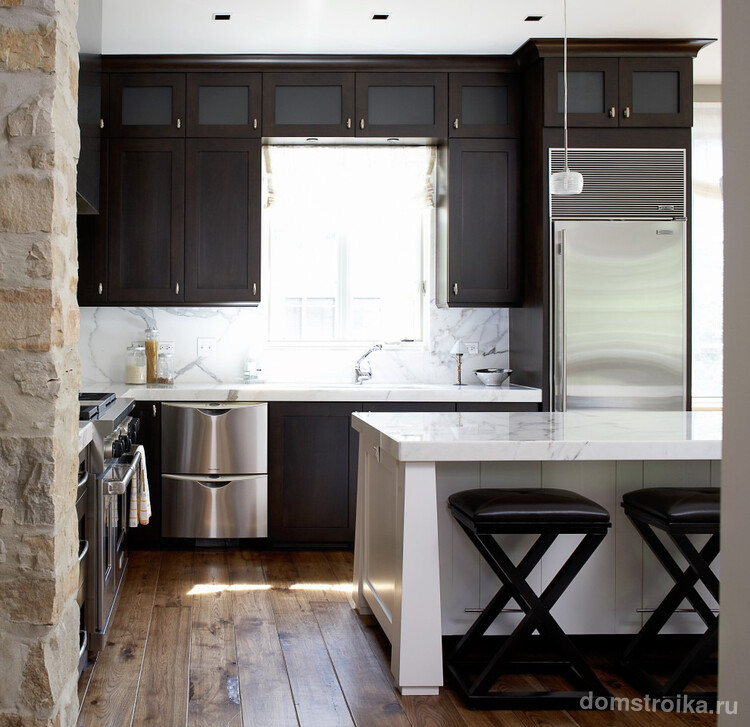 Стильное решение - массивный стол, играющий роль разделителя пространства между кухней и гостиной