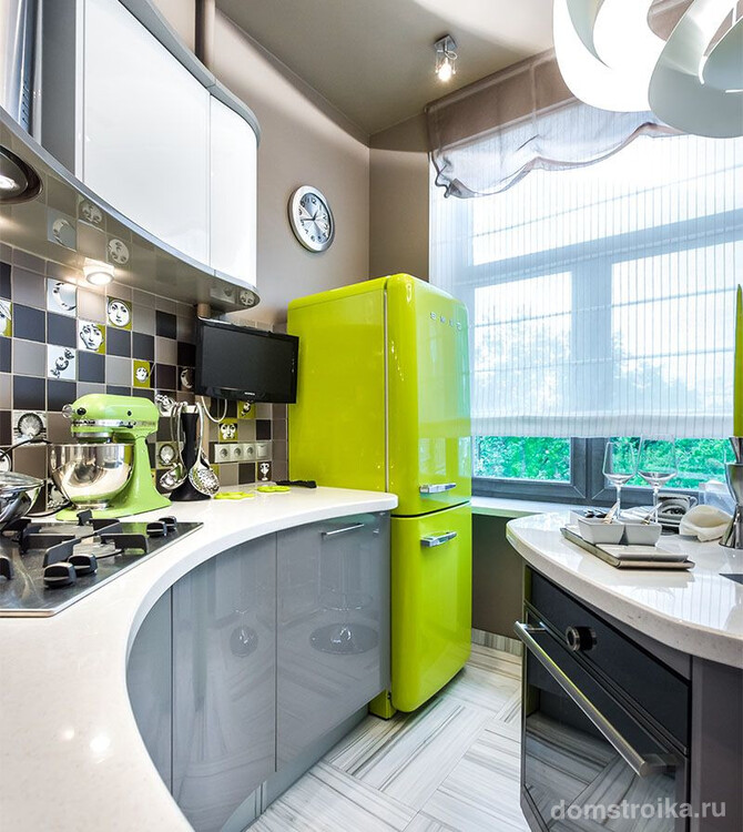 Ярко-зеленый холодильник со скругленными формами отлично вписался в меленькую кухню с бионическими формами