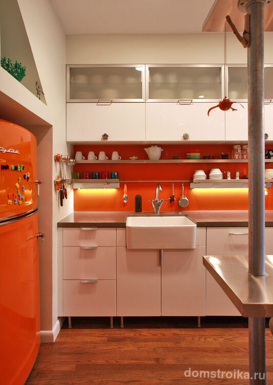 Оранжевый холодильник в тон кухонному фартуку с подсветкой на небольшой кухне