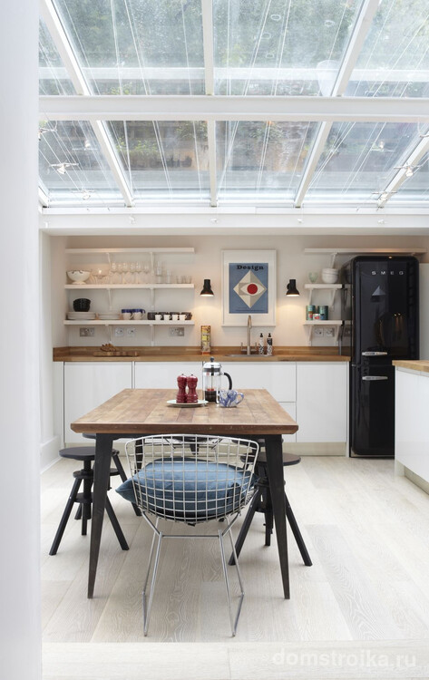 Элегантный черный холодильник на светлой просторной кухне
