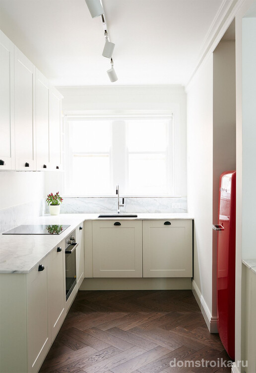 Смелое решение для небольшой светлой кухни - акцентировать все внимание на красном холодильнике
