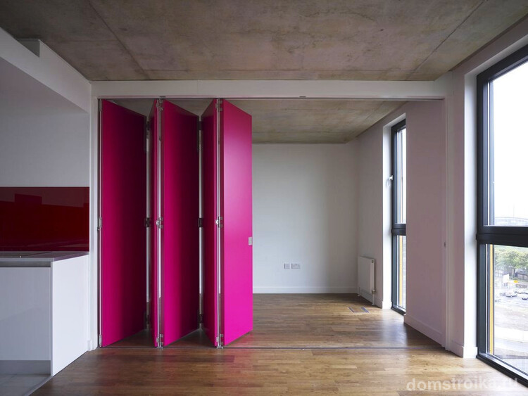 Эффектная складная дверь розового цвета станет ярким элементом декора в интерьере кухни