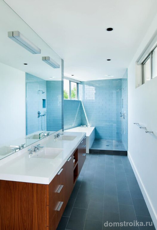 Голубая стеклянная плитка в узкой ванной добавит яркий цветовой акцент