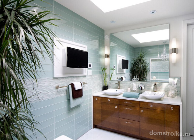 Визуально расширить пространство ванной комнаты поможет глянцевая стеклянная плитка и зеркало