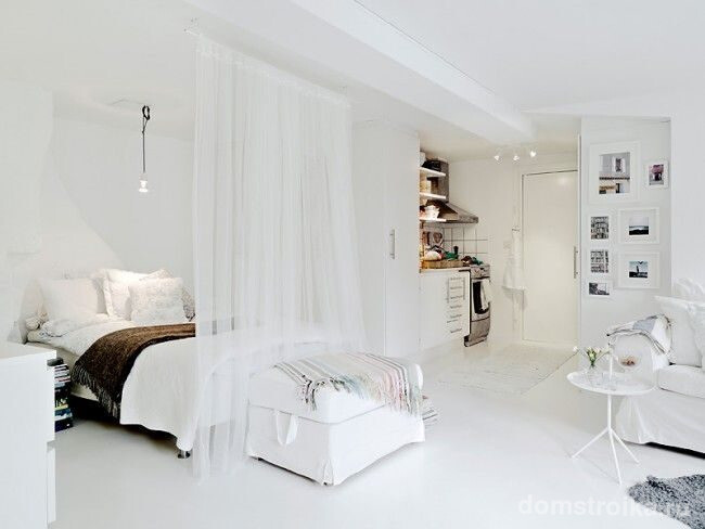 Скандинавский интерьер студии с зонированием спальни с помощью легкой шторы