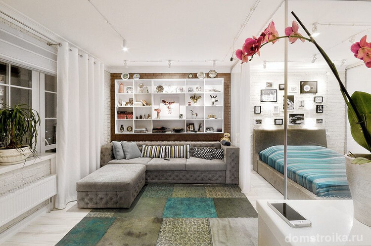 Современный интерьер гостиной с зонированием пространства с помощью легких белых штор
