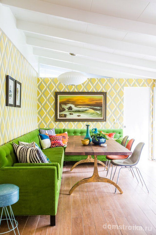 Стиль фьюжн на кухне дополняет мягкий угловой диван насыщенного зеленого цвета