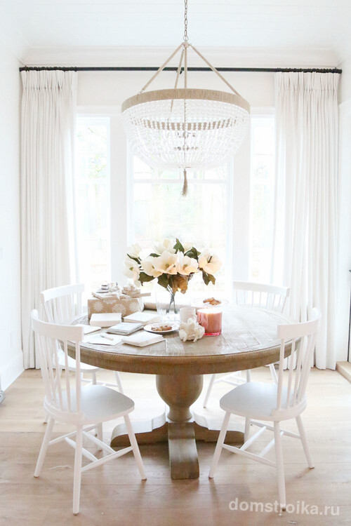 Круглый столик из ореха в интерьере светлой гостиной
