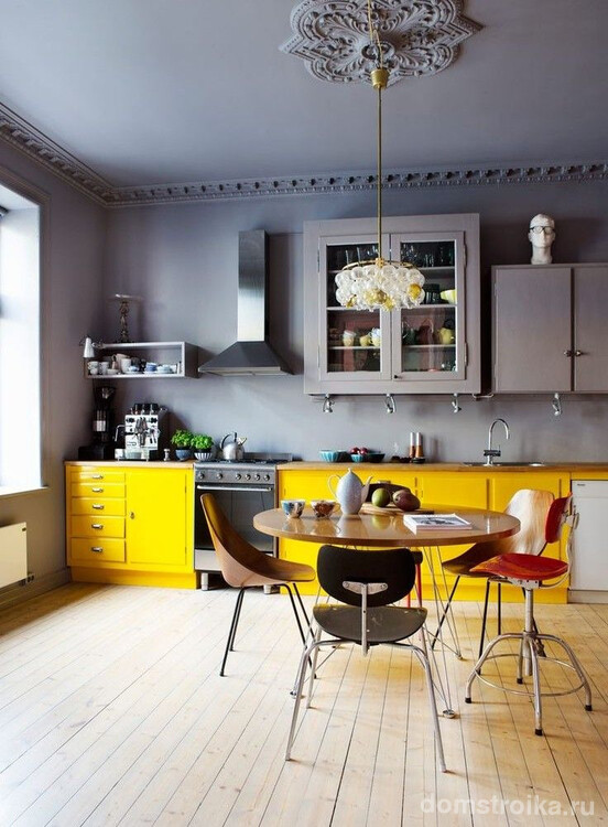 Прекрасное сочетание серого потолка и желтых кухонных шкафов. Обратите внимание на окрашенные полиуретановые розетку и лепнину
