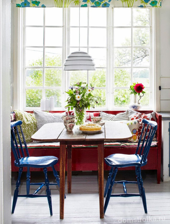 Эклектическая кухня с компактным раскладным столом-книжкой из натурального окрашенного дерева с эффектом состаривания и синими стульями того же эффекта