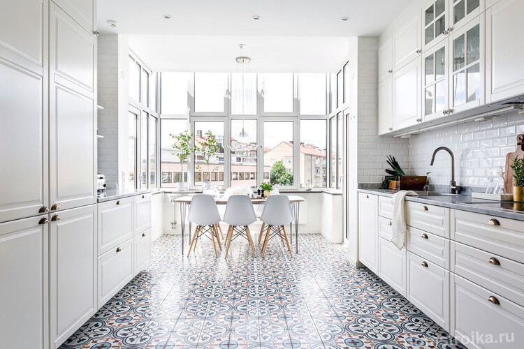 Керамическая плитка с узором контрастирует на фоне белой мебели и стен кухни скандинавского стиля