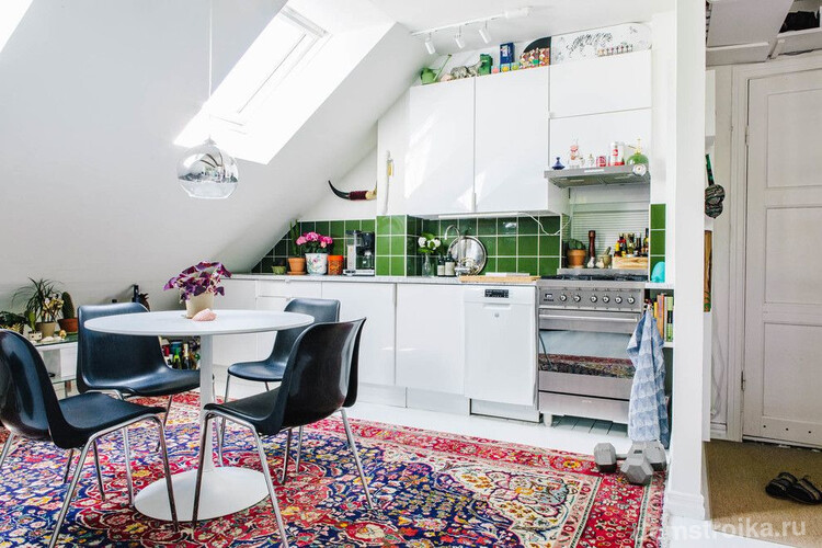 Фартук из зеленой плитки и яркий ковер на полу добавят ярких красок в стандартный скандинавский стиль кухни