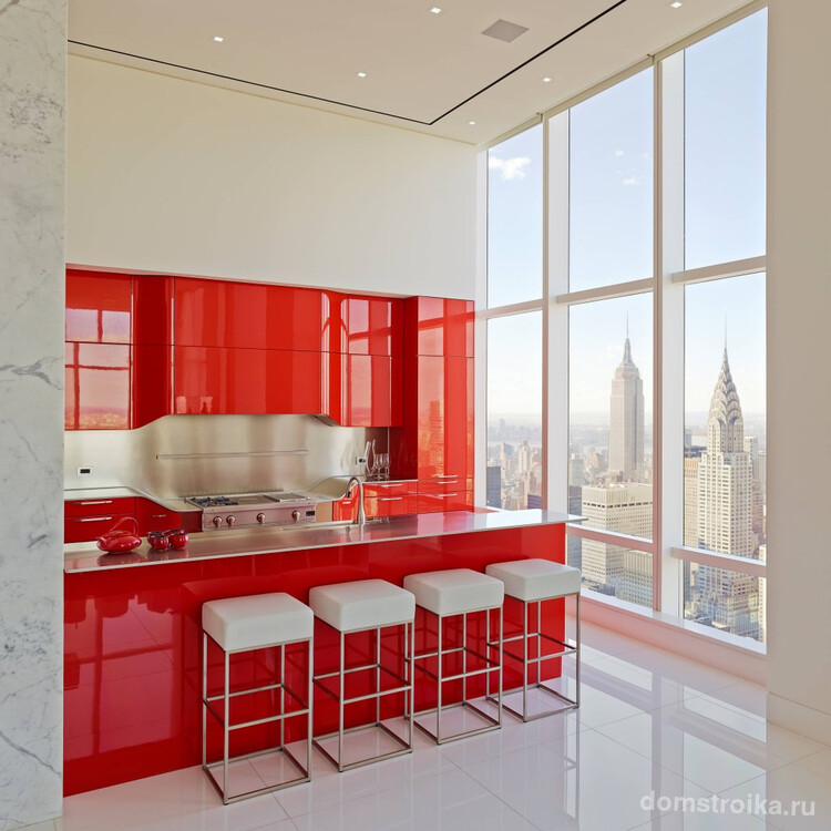 Яркий красный гарнитур акцентирует внимание на рабочей зоне кухни-студии