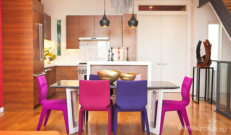 Светлая кухня-студия с яркими стульями, которые являются главным акцентом комнаты. Обратите внимание, что большой стеклянный стол также поможет визуально увеличить пространство, придав ему легкости и воздушности
