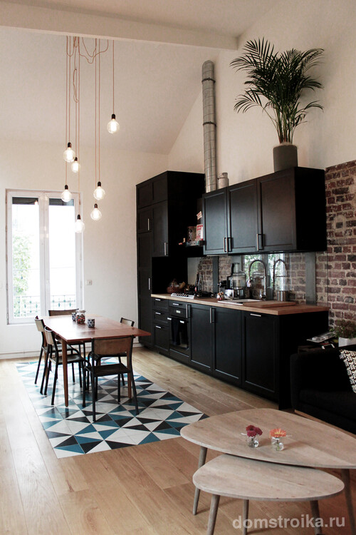 Оригинальная плитка с геометрическим орнаментом отлично зонирует обеденную зону на кухне-студии