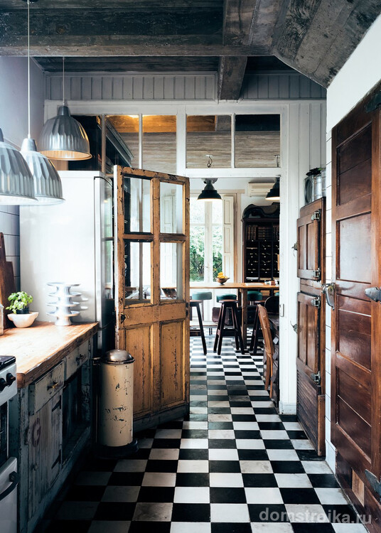 Уютная кухня в винтажном стиле с классической черно-белой плиткой на полу