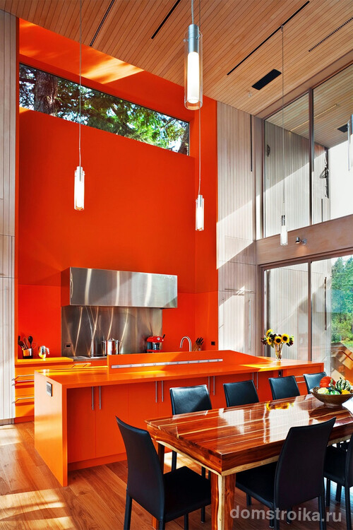 Обилие оранжевого в сочетании с теплыми оттенками дерева на полу и потолке