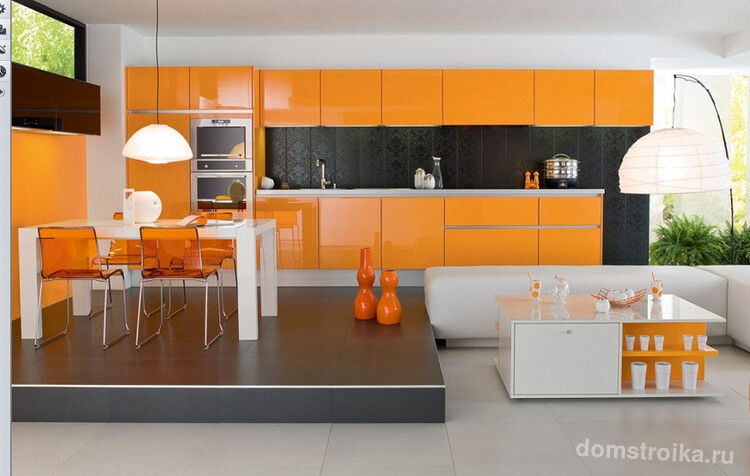 Современная оранжевая кухня со столовой зоной на подиуме