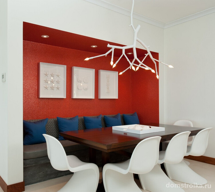 Белая кухня средних размеров с модерновыми акцентами: ярко-красной нишей и броским подвесным светильником