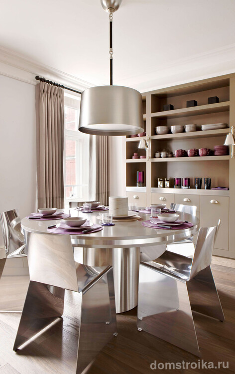 Шлифованные зеркальные поверхности круглого столика и угловатых стульев: вместе они составляют центральную композицию в кухне