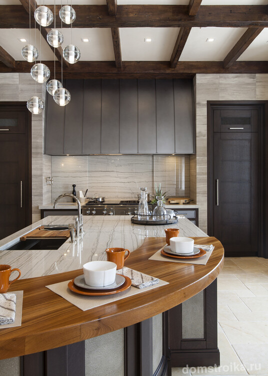 Соединение мрамора и дерева в пределах одной столешницы - интересная деталь в интерьере кухни