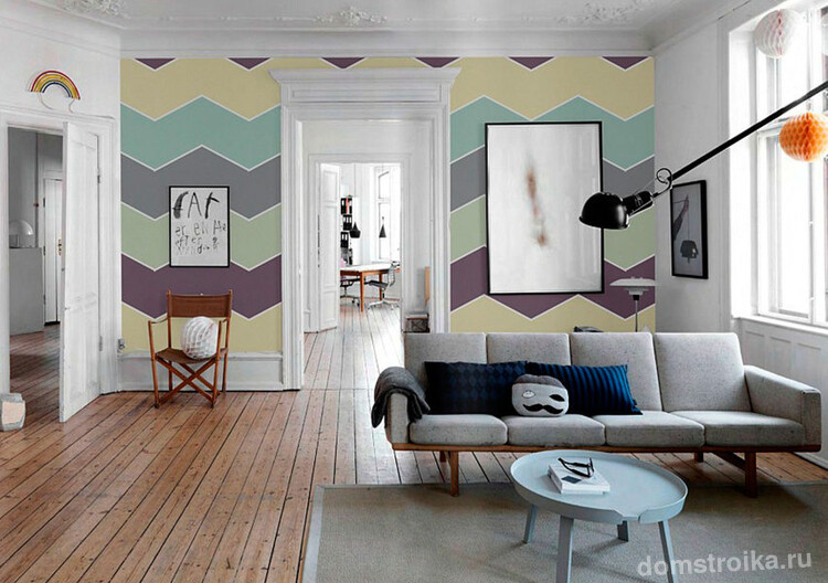 В комнате с высокими потолками разноцветные обои зигзагообразного рисунка