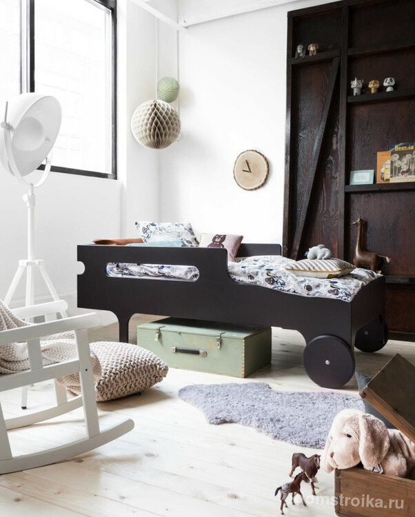 Мебель из темного дерева стильно выделяется в белоснежных стенах детской комнаты