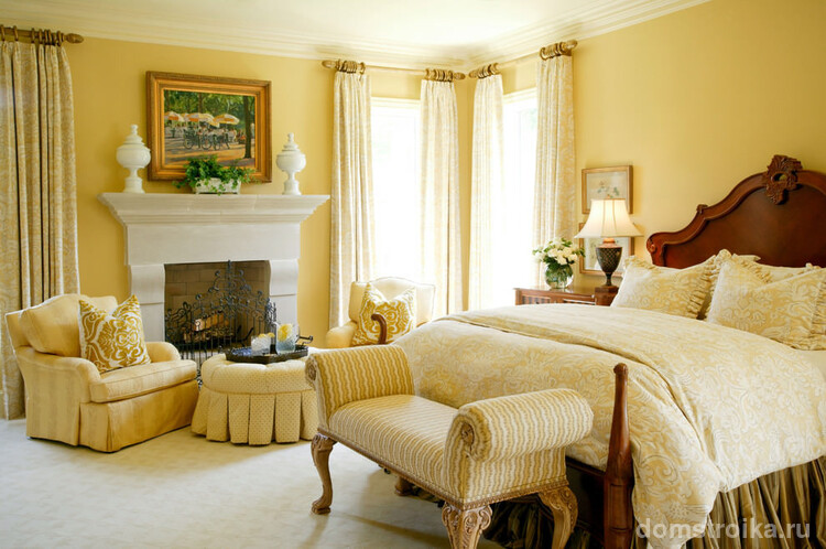 Пастельные тона комнаты располагают к спокойствию и отдыху, а декоративный белый камин подчеркивает классический стиль спальни