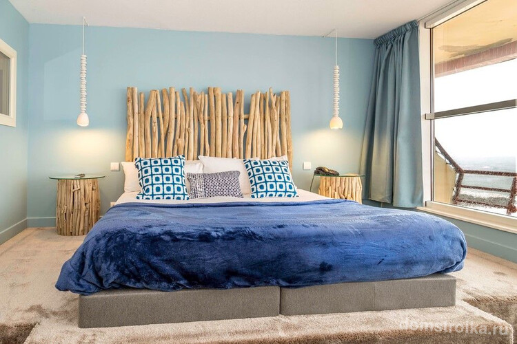 Для спальни морской тематики подойдут голубые шторы по длине окна