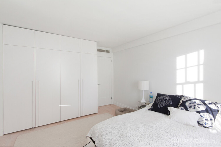 Белая спальня с вместительным корпусным шкафом с матовой поверхностью