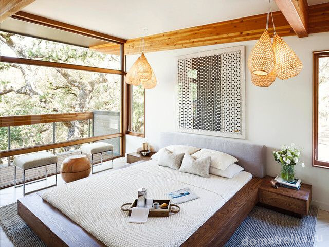 Красивая светлая спальня с панорамным видом оформленная в эко стиле