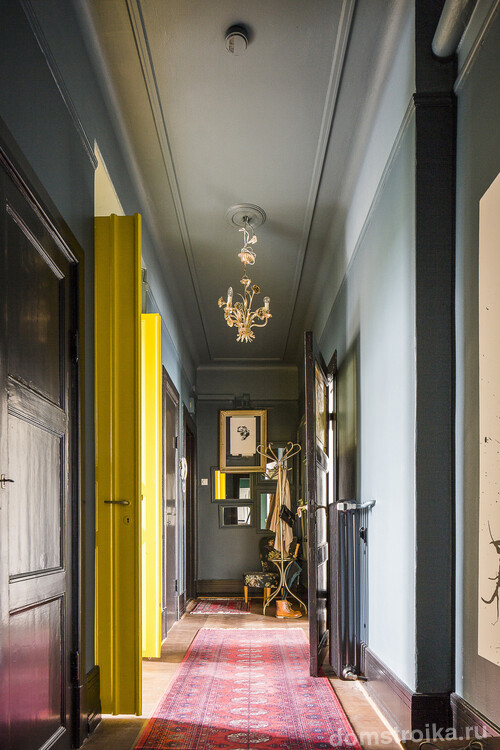 Оригинальный дизайн узкого коридора с акцентами на ярко-желтых дверях и практичном, легкоочищающемся покрытии на стенах